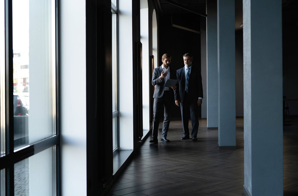 Dos colegas conversando en el pasillo de una oficina corporativa