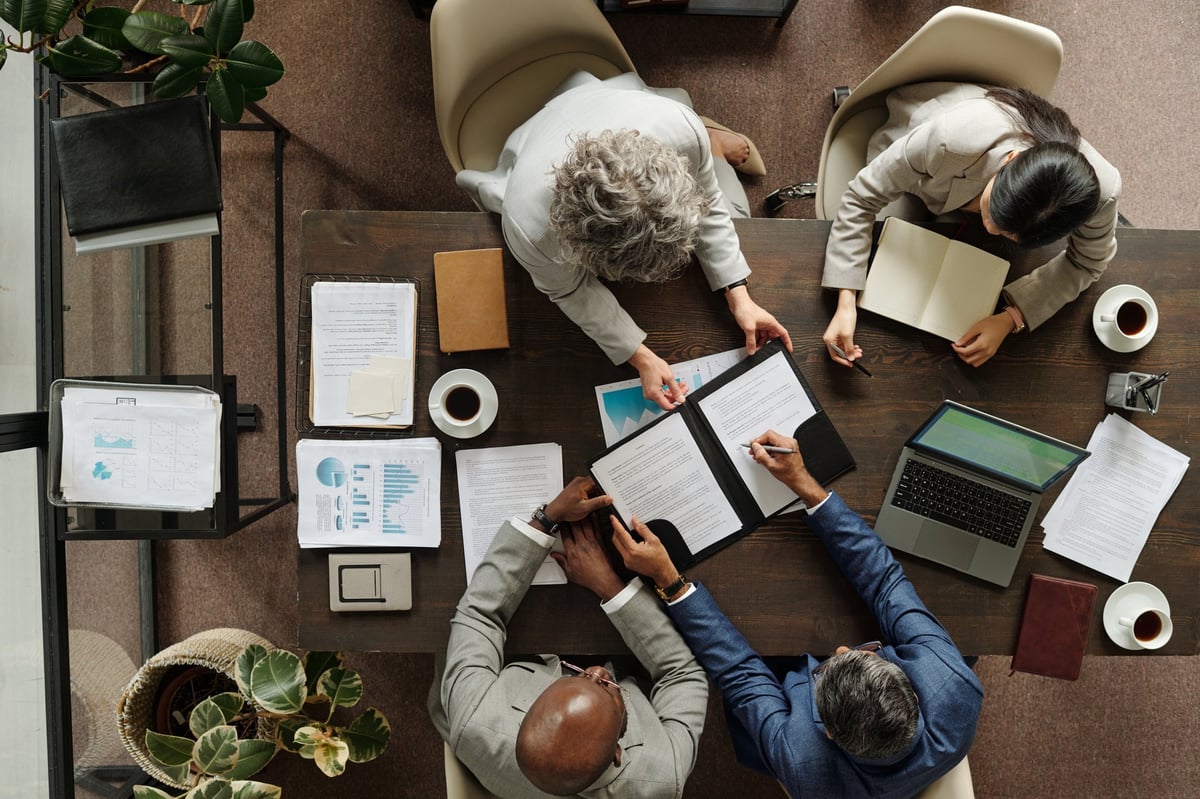 Equipo de estrategas de CNK colaborando en una mesa de trabajo corporativo