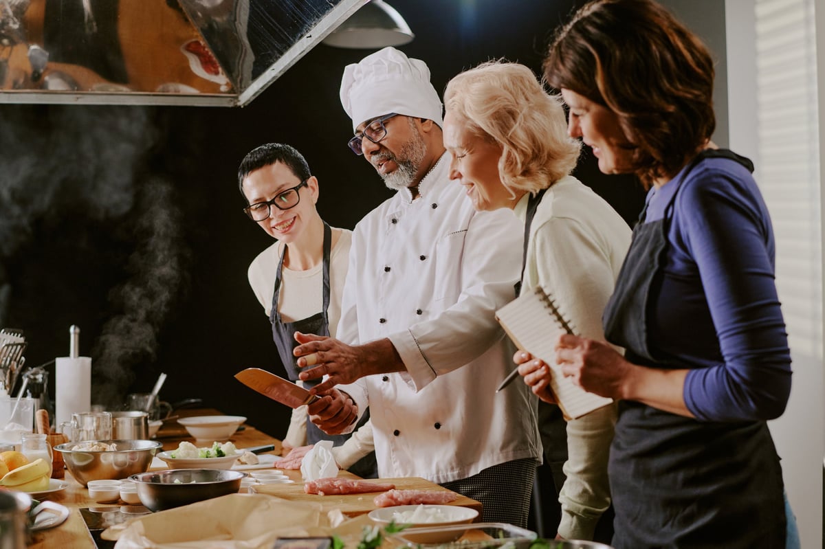 Chef demostrando técnicas de cocina a un grupo durante una clase gastronómica